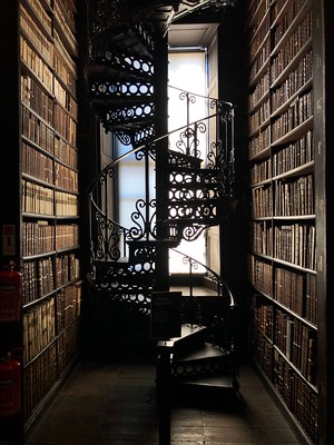 a dark spiral staircase in a library